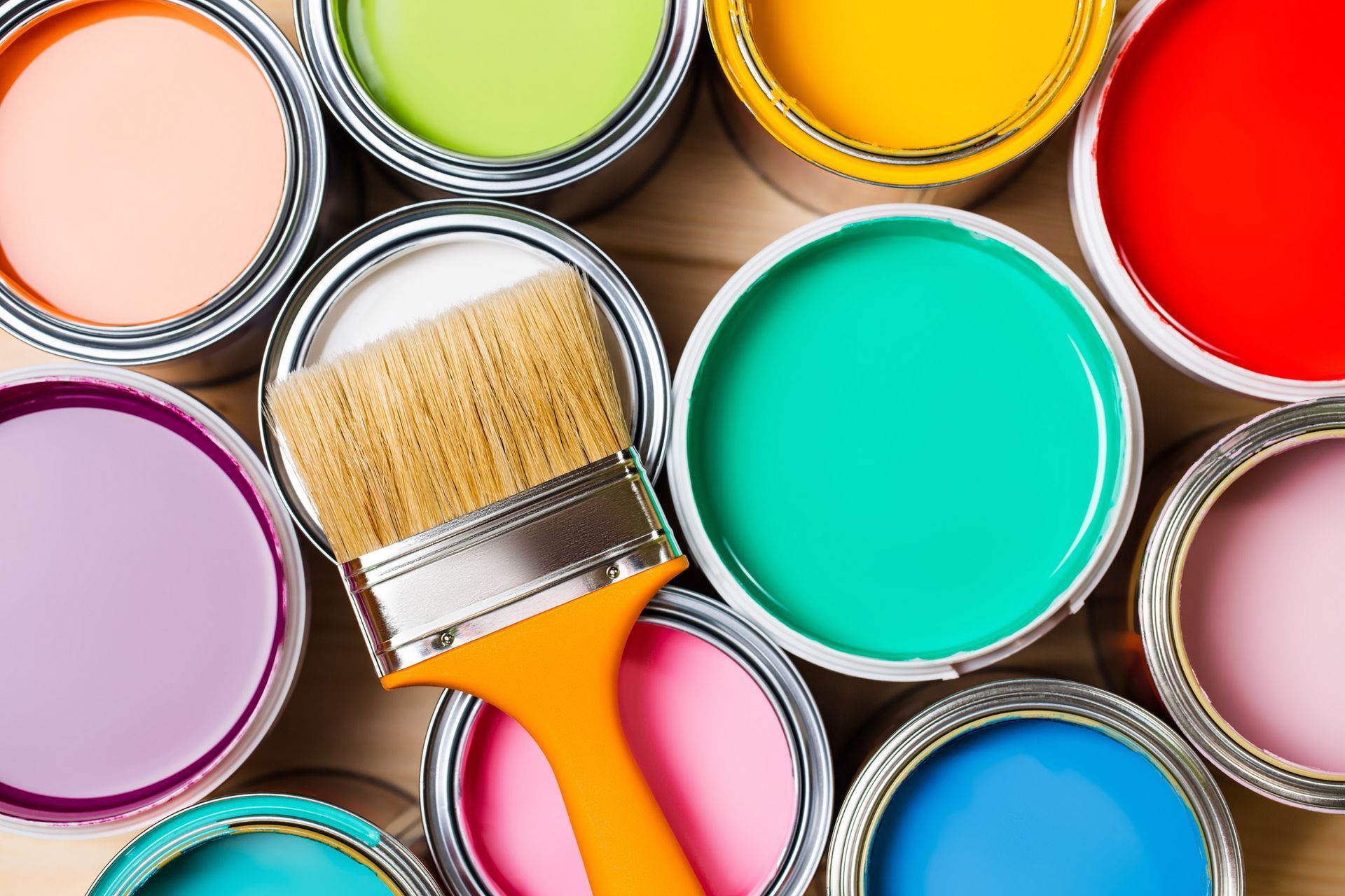 Paint cans with various colors and a paintbrush.