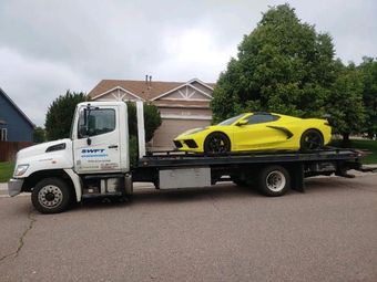 SWFT Towing tow truck flatbed towing a car in Colorado Springs - Professional and fast car towing services.