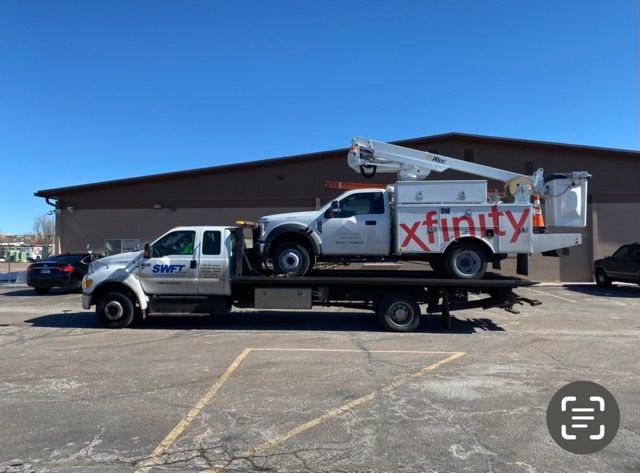 A xfinity truck is being towed by a tow truck