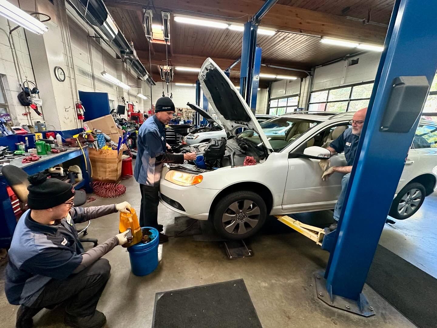 Two Mechanics Are Working On A White Car In A Garage | The V Shop