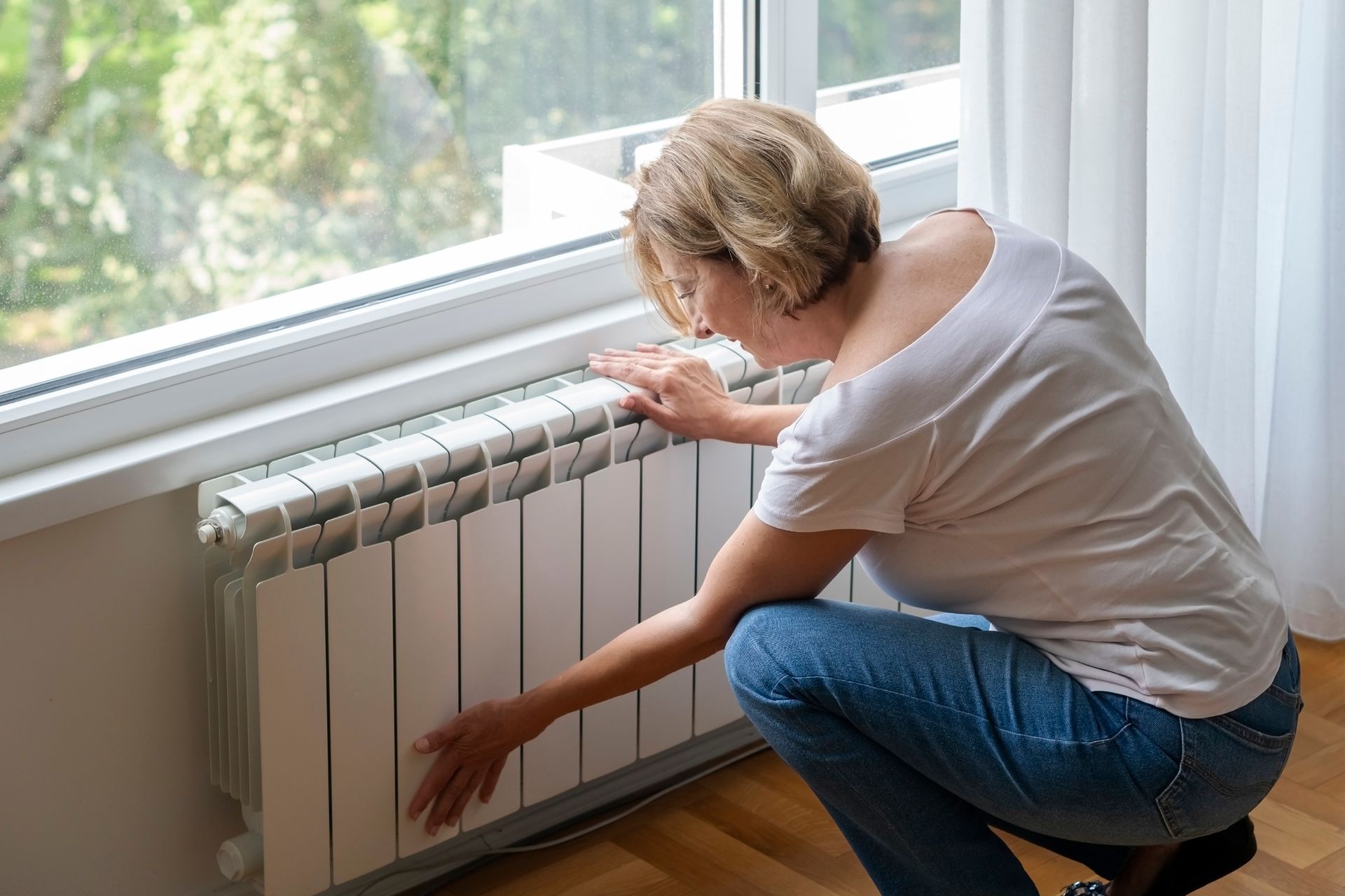 Woman touching cold home furnace.