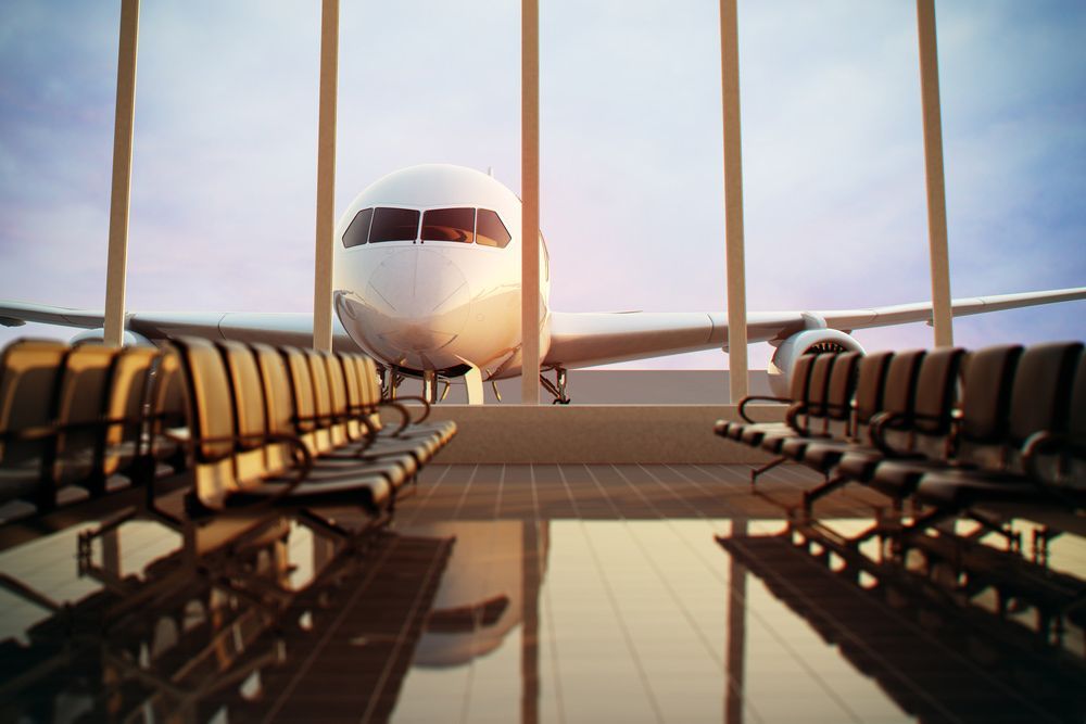 An Airplane is Seen Through Airport Windows — Dave's Drive U Anywhere 24/7 Mini Van Hire In Shellharbour, NSW