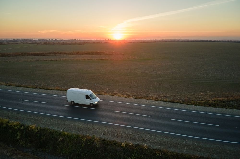 White Van Driving on Road at Sunset — Dave's Drive U Anywhere 24/7 Mini Van Hire In Shellharbour, NSW