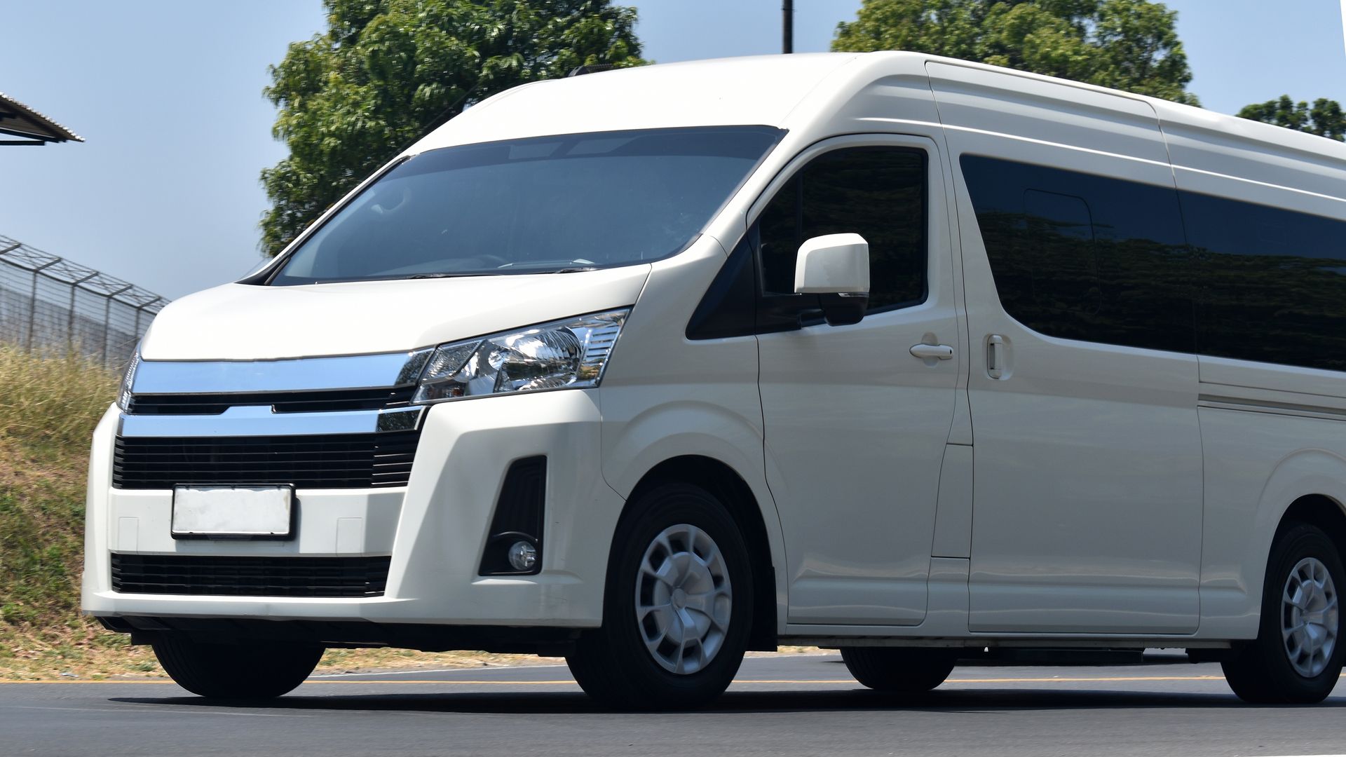 White Passenger Van Driving on a Road — Dave's Drive U Anywhere 24/7 Mini Van Hire In Kiama, NSW