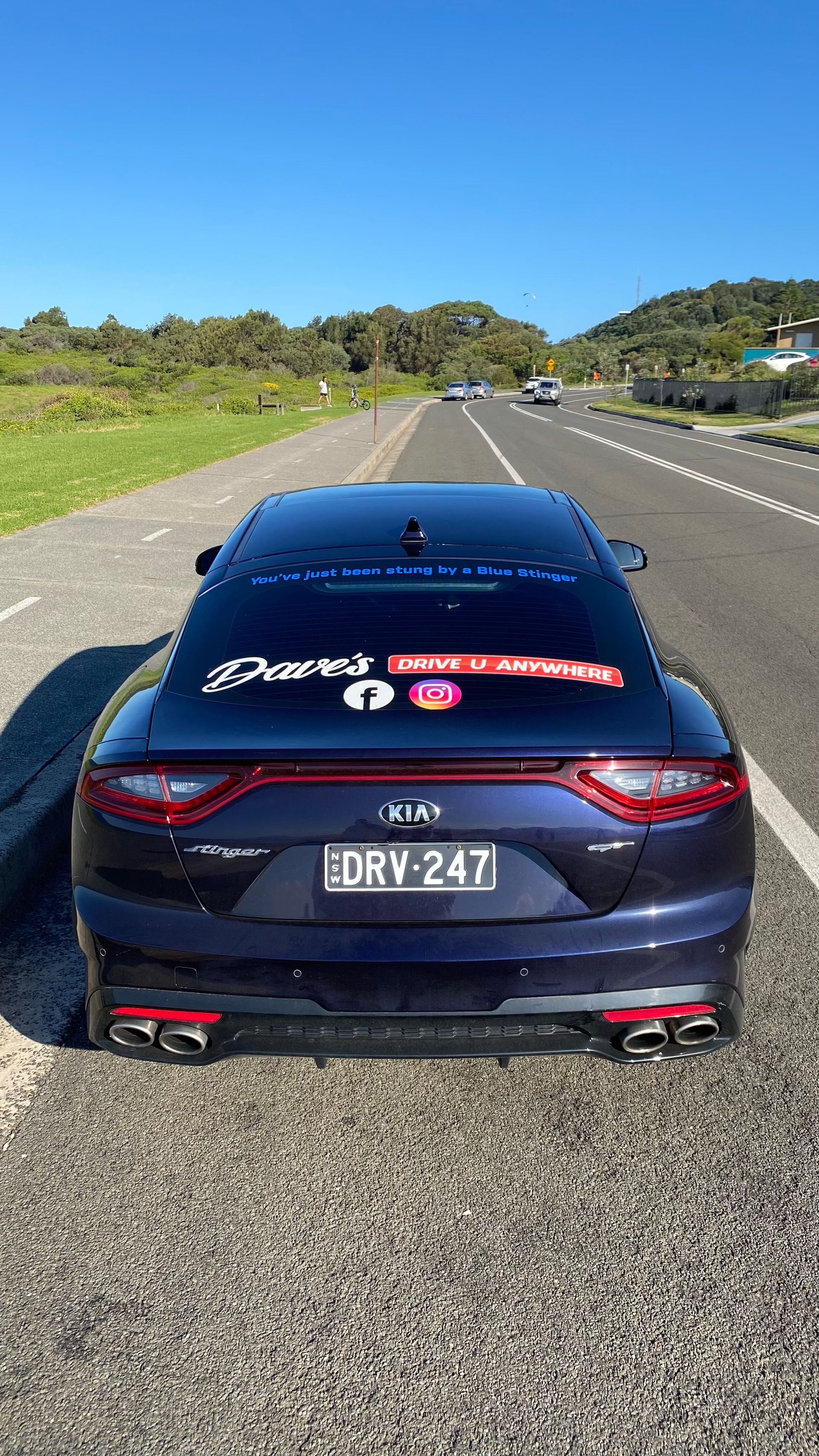 Rear View of a Dark Blue Kia Stinger — Dave's Drive U Anywhere 24/7 Mini Van Hire In Wollongong, NSW