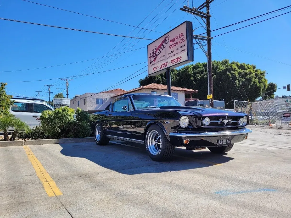 A black mustang is parked in a parking | Ed Hanson's Muffler Service