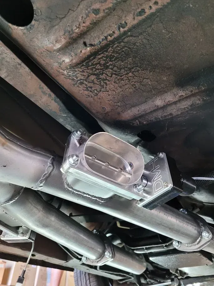 A close up of the underside of a car with a exhaust pipe | Ed Hanson's Muffler Service