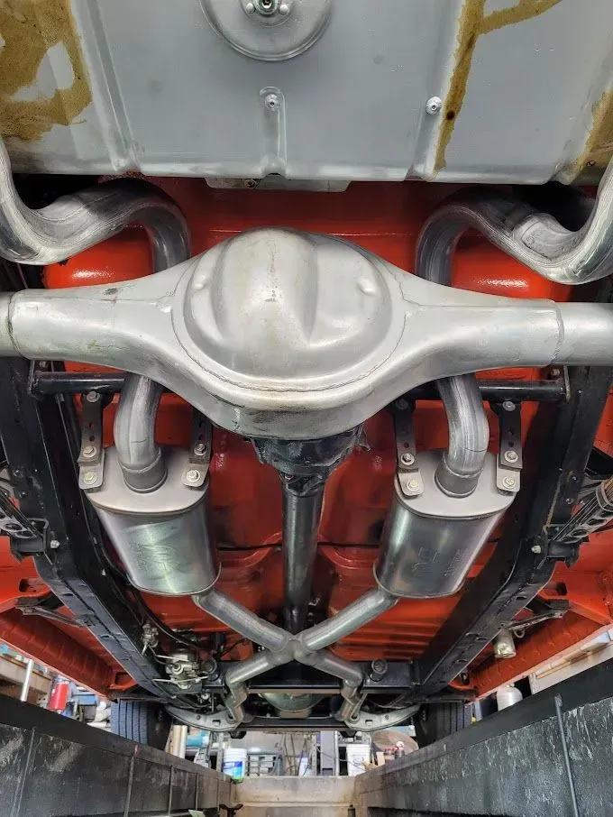 A close up of the underside of a car with exhaust pipes | Ed Hanson's Muffler Service