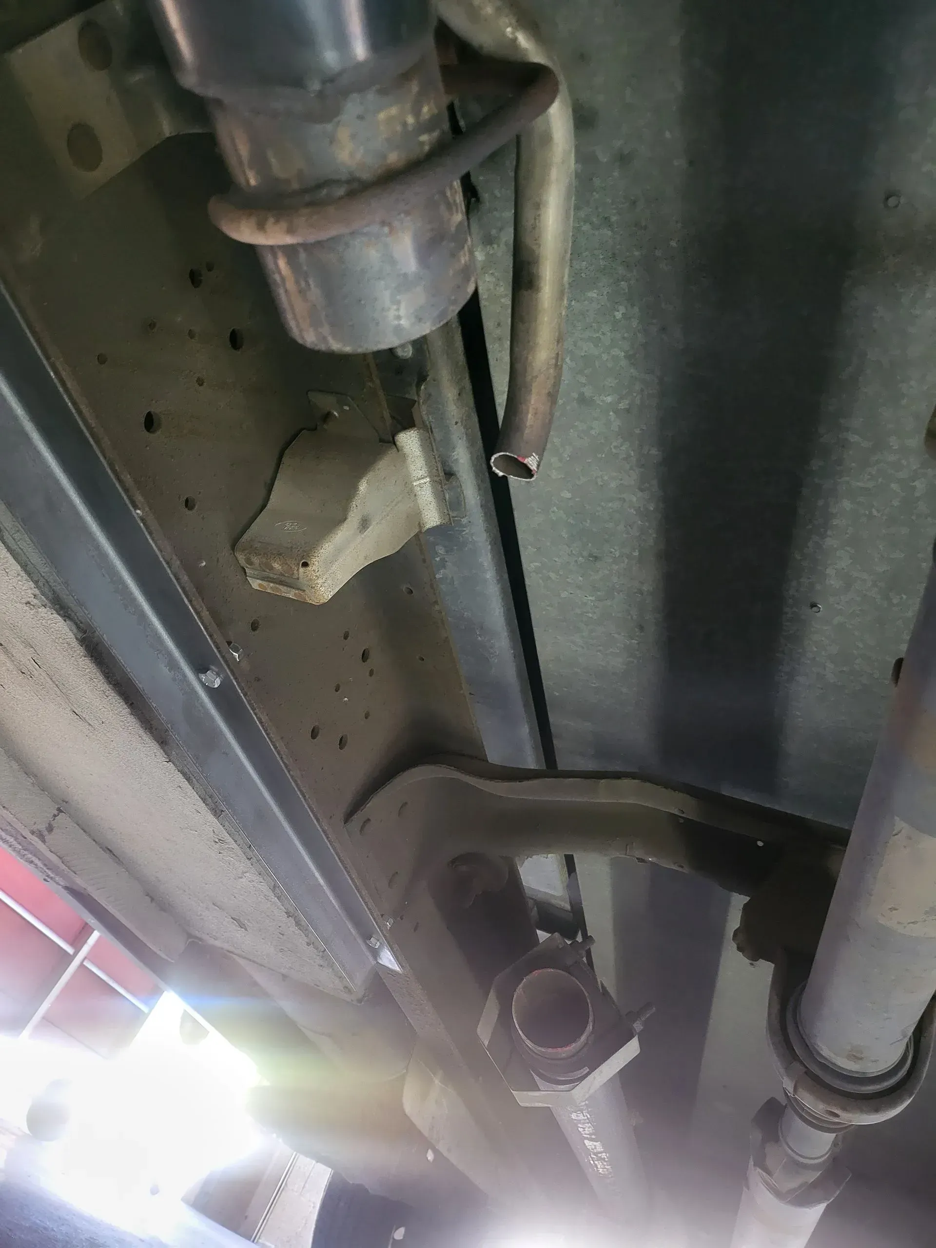 A close up of a exhaust pipe under a car | Ed Hanson's Muffler Service
