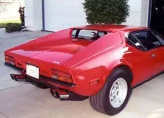 A red sports car is parked in front of a garage | Ed Hanson's Muffler Service