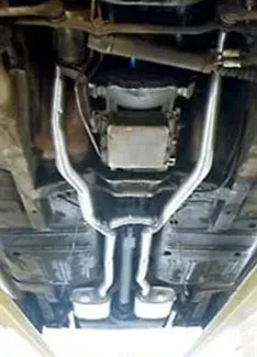A close up of the underside of a car with exhaust pipes | Ed Hanson's Muffler Service