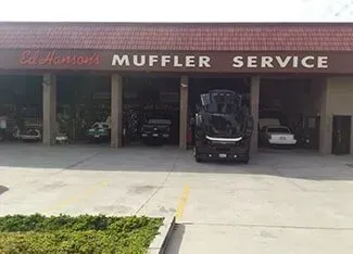 A car is parked in front of a muffler service garage | Ed Hanson's Muffler Service