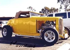 A yellow hot rod is parked in a parking lot | Ed Hanson's Muffler Service