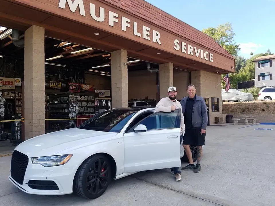 Two People Stand in Front of Ed Hanson's Muffler Service in Valley Springs, CA