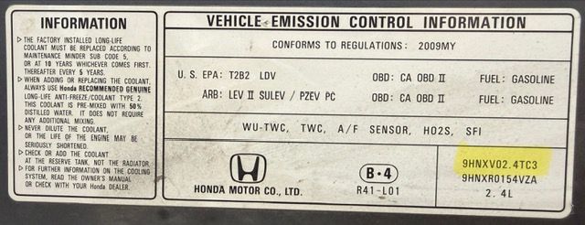 A Honda vehicle emission control information sticker detailing engine, fuel, and coolant specifications.