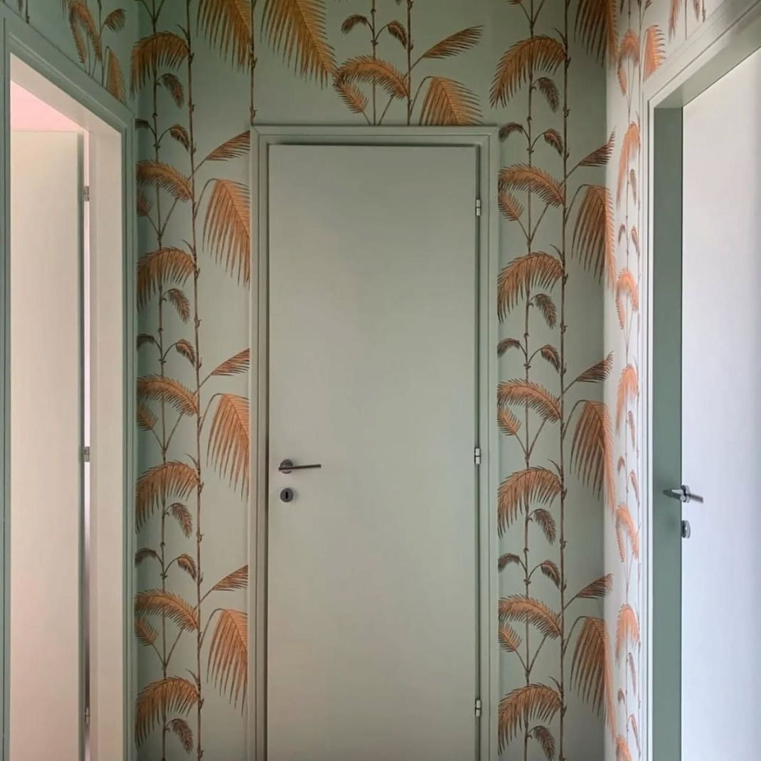 Porta doppia marrone con pannelli decorativi, ferramenta dorata.