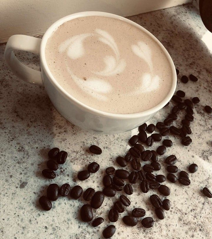 A cup of cappuccino with a swirl design on top