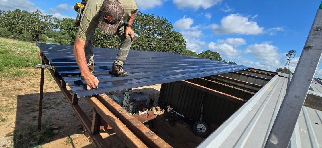 Worker installing black solar panels on a rooftop under a blue sky