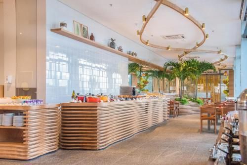 Buffet moderno e luminoso em um restaurante elegante com detalhes em madeira e plantas suspensas.