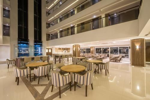 Átrio de hotel moderno com mesas de café vazias e piso de mármore brilhante à noite.