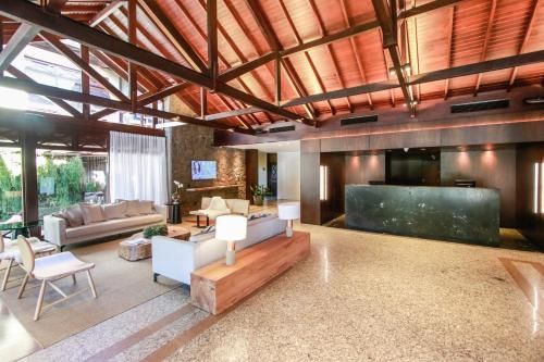 Sala de estar moderna e espaçosa com vigas de madeira expostas, área de estar e balcão de recepção escuro.