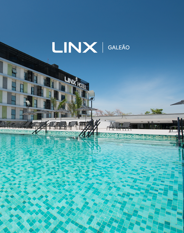 Piscina moderna de hotel com água turquesa e um edifício da marca LINX sob um céu azul claro.