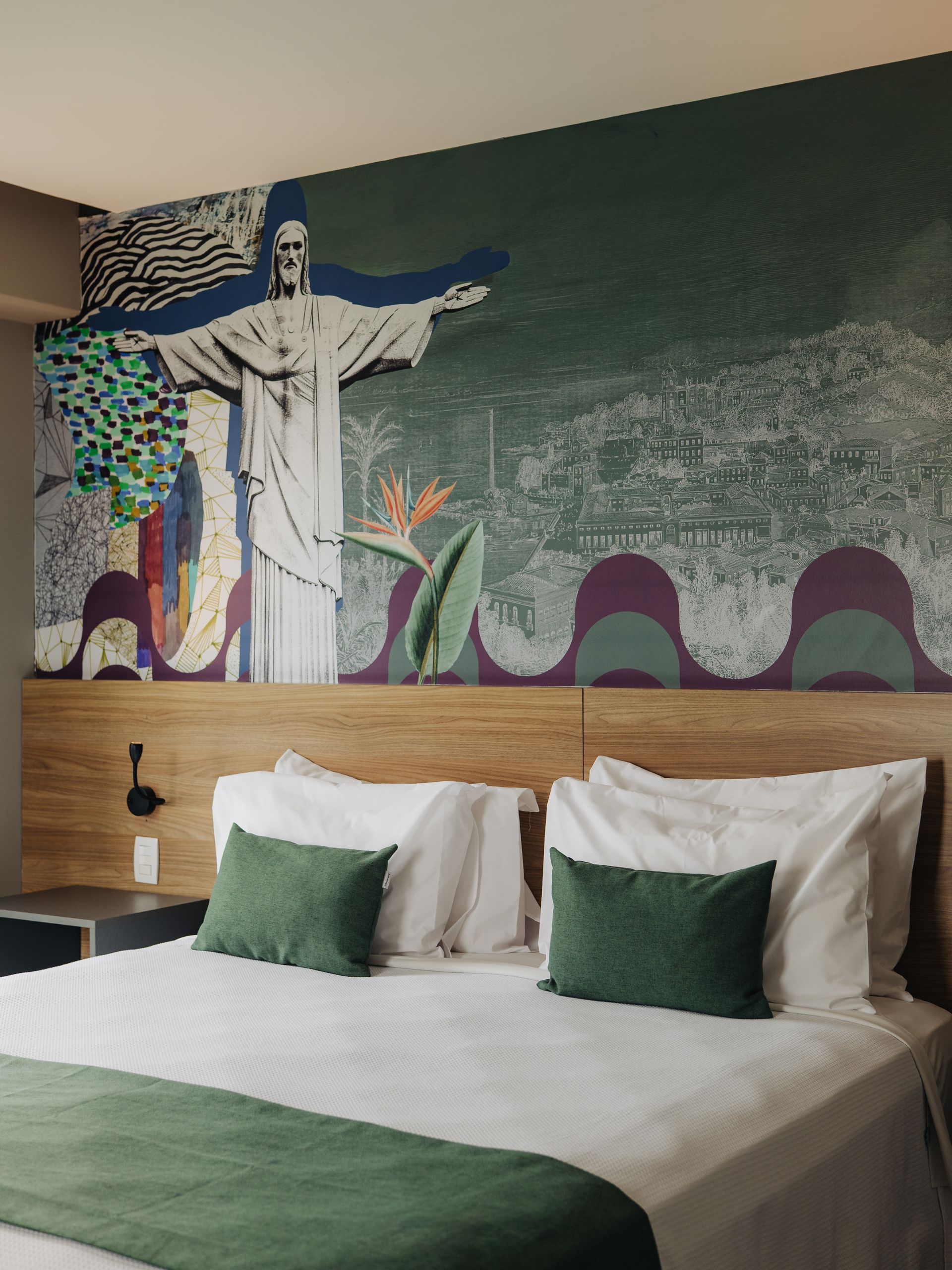 Quarto moderno com cama, parede com detalhes em madeira e uma pequena mesa junto a uma janela ampla.