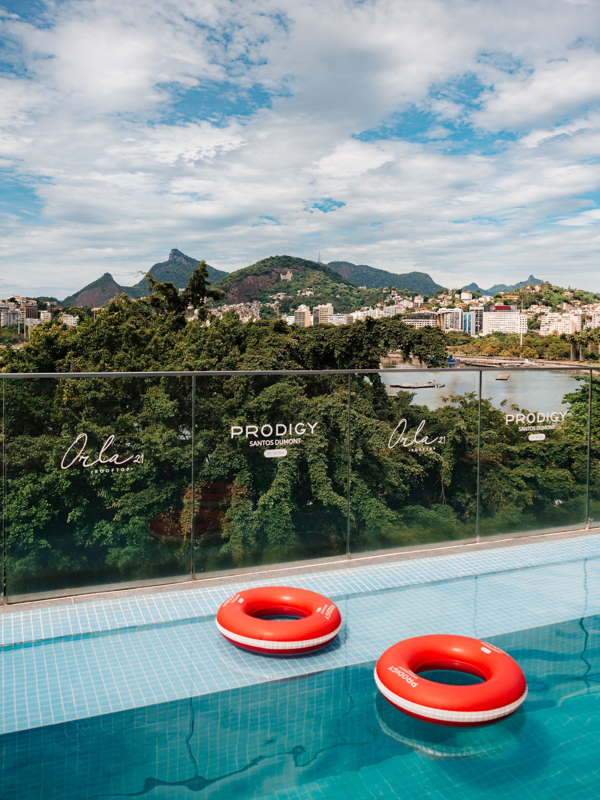 Piscina infinita na cobertura ao entardecer, com espreguiçadeiras, iluminação aconchegante e vista para a montanha.