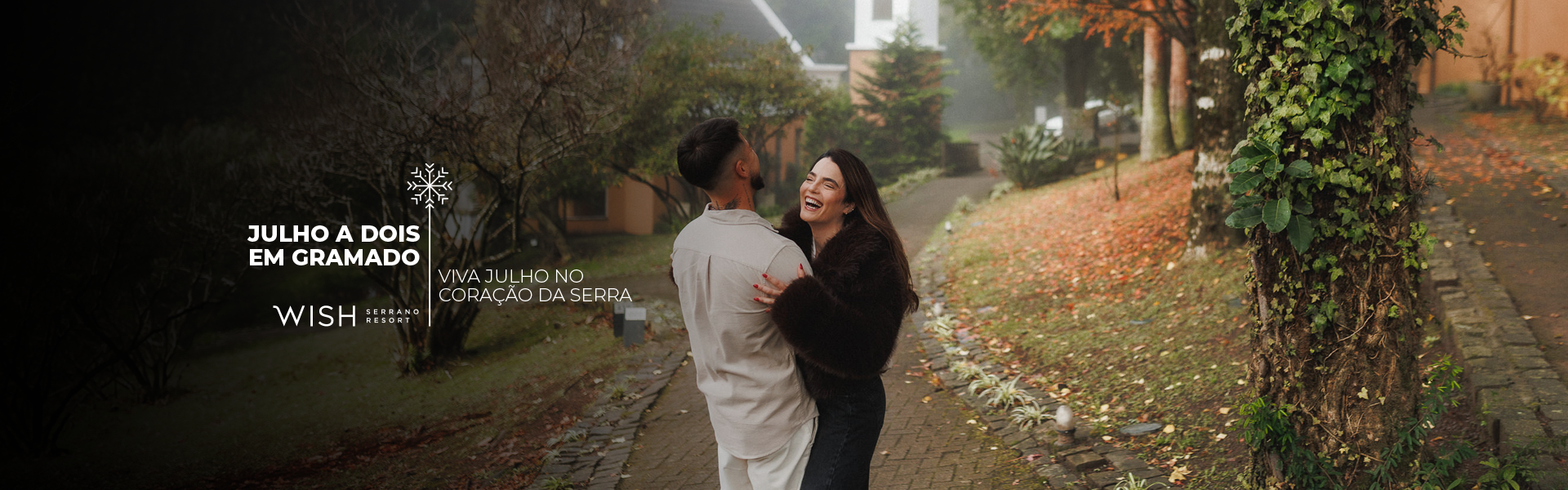 Casal se abraçando em uma alameda arborizada no outono, com texto branco à esquerda.