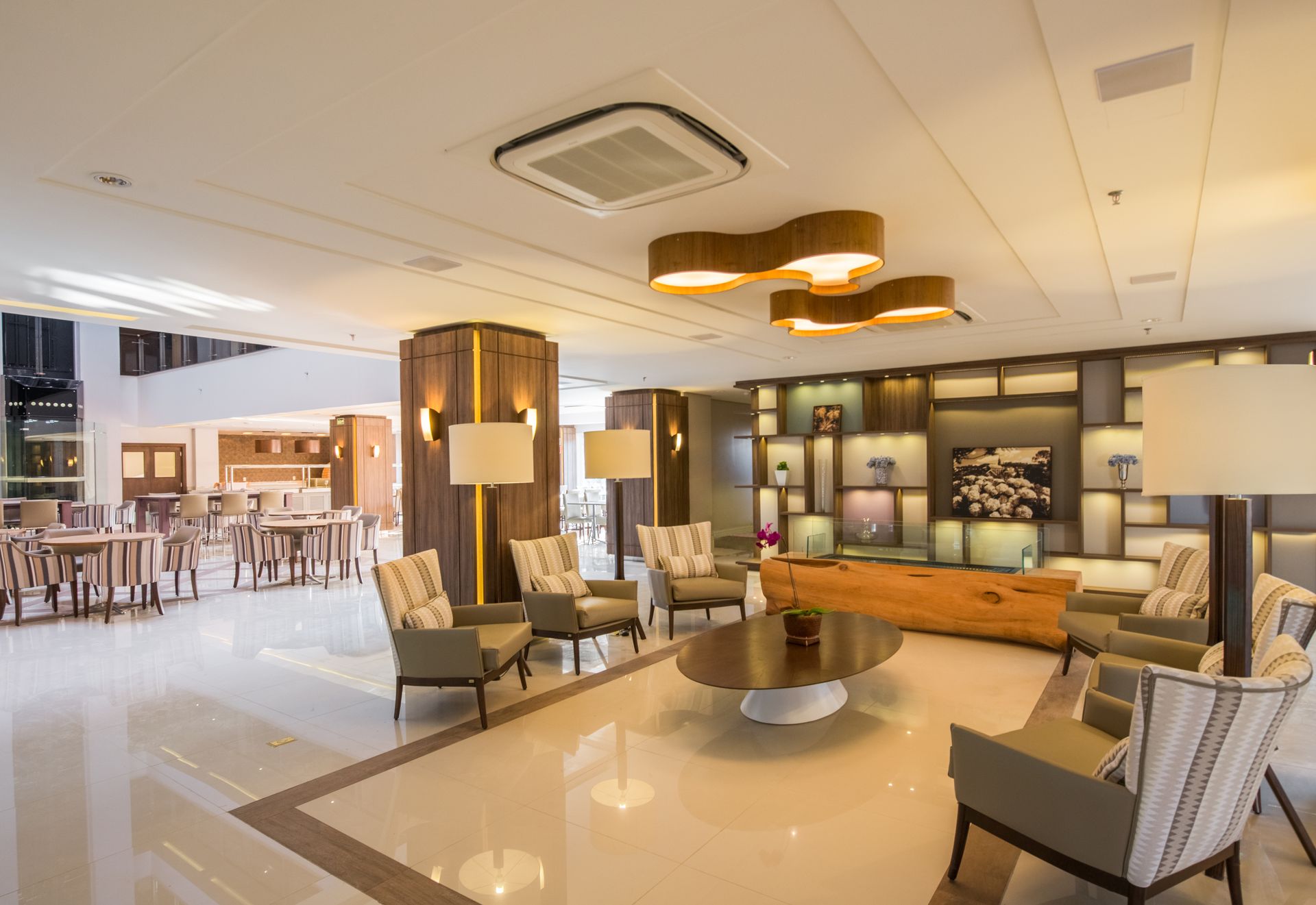 Hall de entrada moderno do hotel com assentos, iluminação aconchegante e área de recepção.