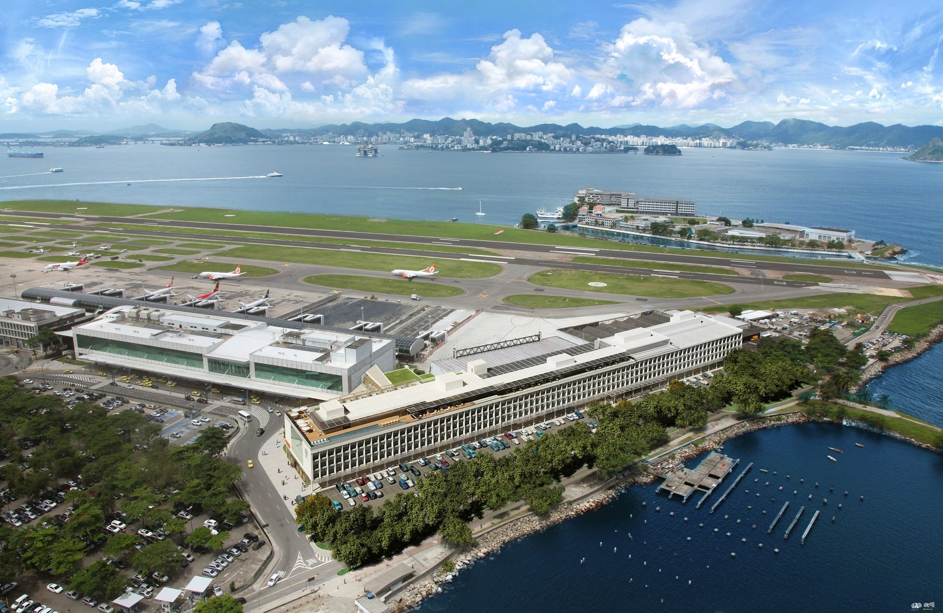Vista aérea da pista de um aeroporto costeiro junto à água e edifícios da cidade sob um céu nublado.