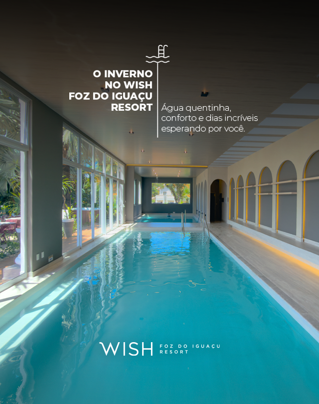 Piscina interna turquesa no Wish Foz do Iguaçu Resort, com janelas em arco e luz refletida.