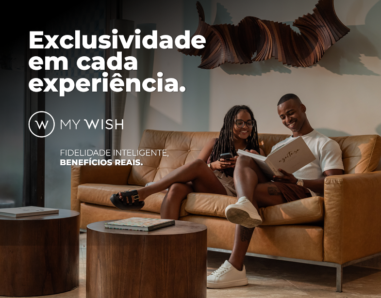 Sala de estar com casal no sofá, texto “Exclusividade em cada experiência” e “My Wish”.