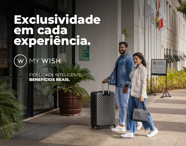 Casal com malas entra em hotel de luxo; texto: “Exclusividade em cada experiência. MY WISH”