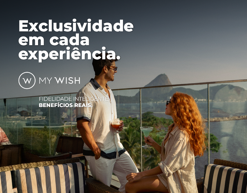 Casal em varanda com vista para as montanhas, sob texto promocional “Exclusividade em cada experiência.”