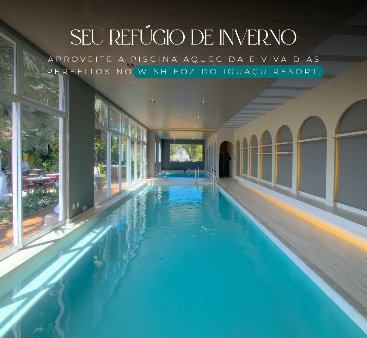 Indoor turquoise pool corridor with arched windows and sunlight, under “SEU REFÚGIO DE INVERNO” text overlay