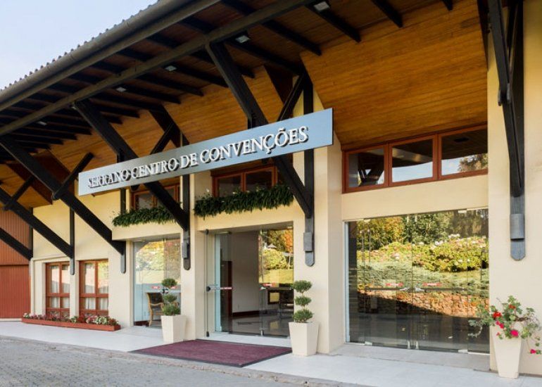 Entrada de um edifício moderno de madeira com uma placa 