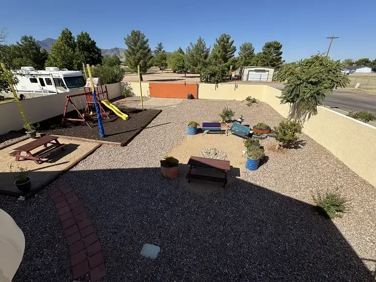 An aerial view of a backyard with a playground and a rv in the background