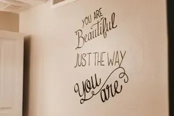 A wall with a quote on it that says `` you are beautiful just the way you are ''.