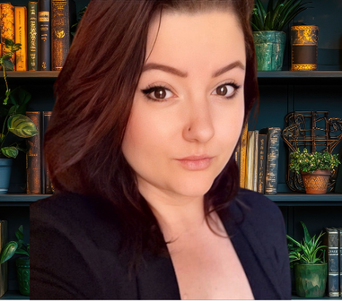 Portrait of a woman in a dark blazer in front of bookshelves and potted plants