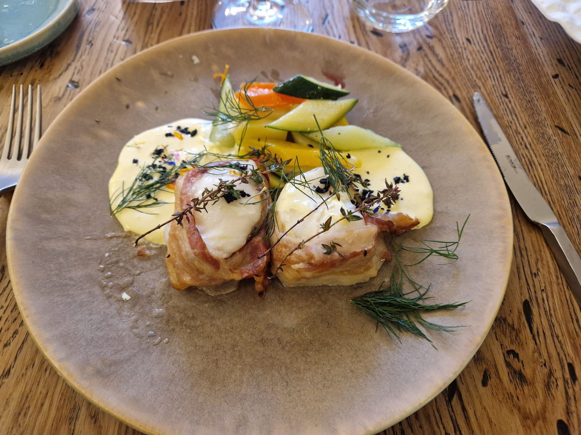 Une assiette de nourriture avec de la viande et des légumes sur une table en bois