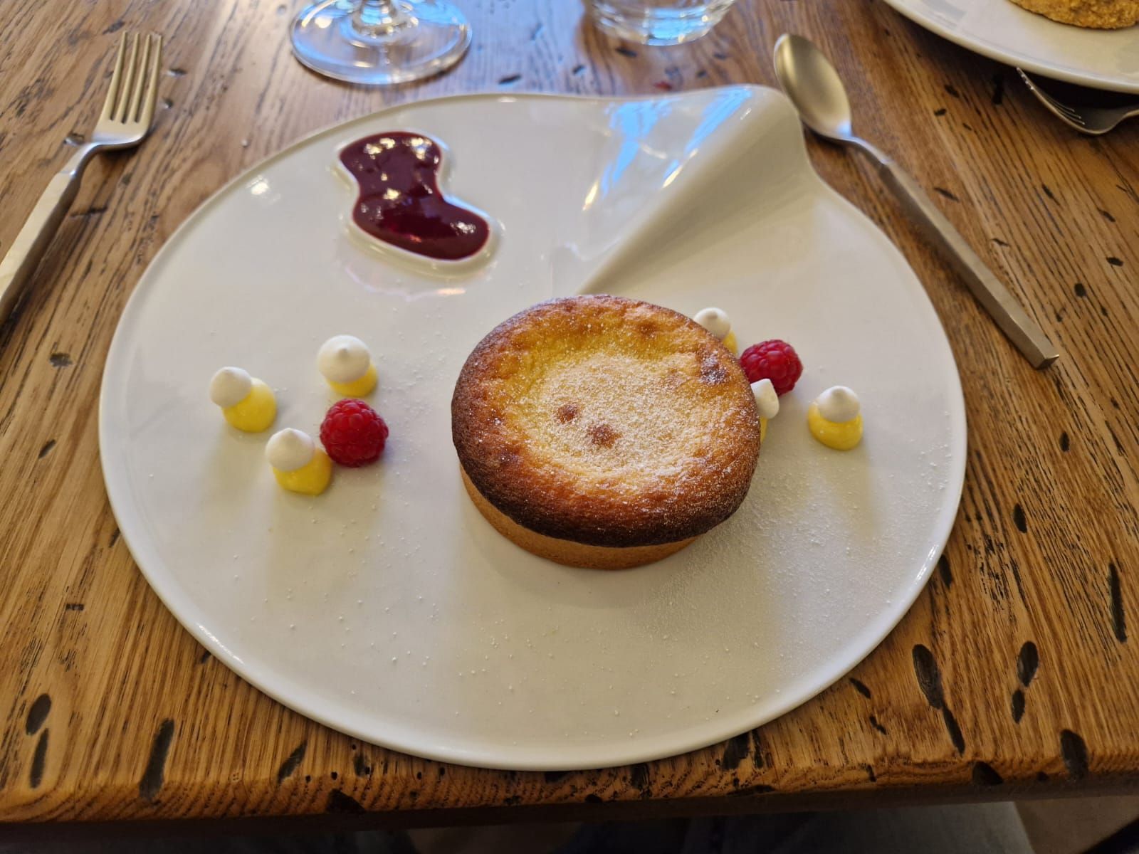 Une assiette blanche garnie d'un dessert sur une table en bois.
