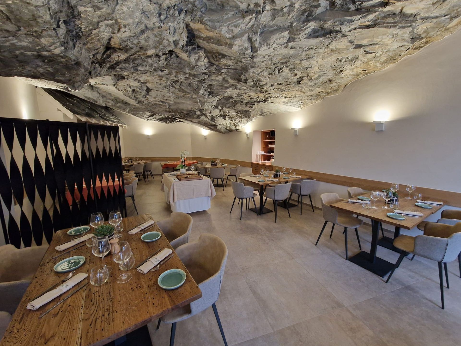 Un restaurant avec des tables et des chaises et un plafond qui ressemble à une grotte.