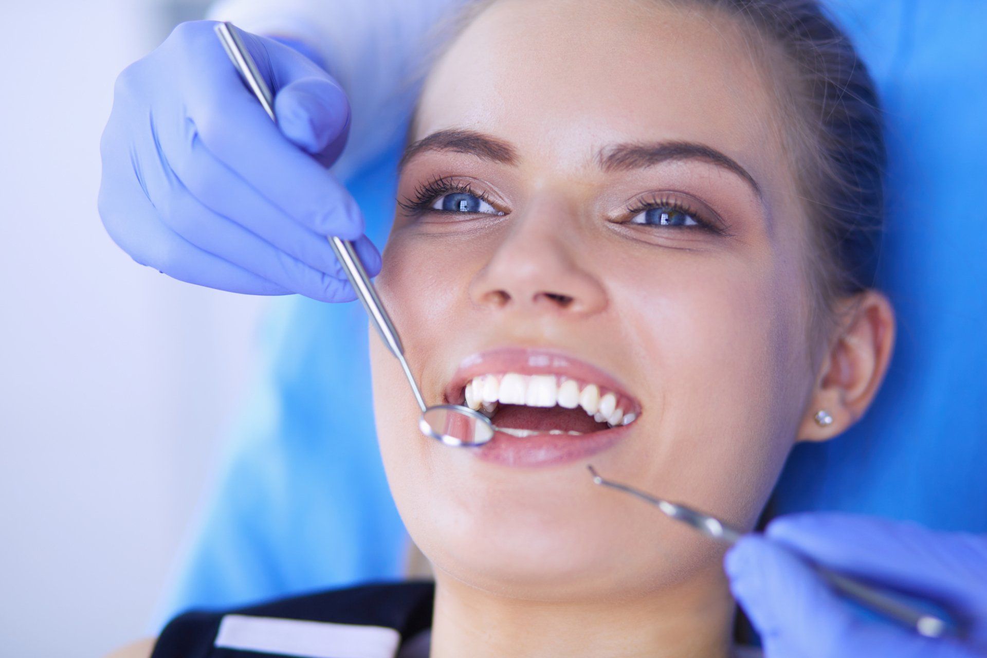 A woman is having her teeth examined by a dentist.