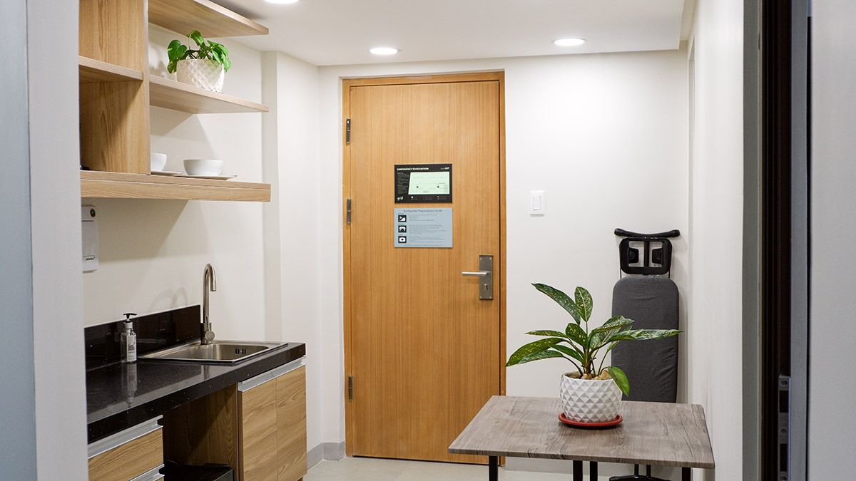 The Grid in Makati: A kitchen with a sink , table , and ironing board.