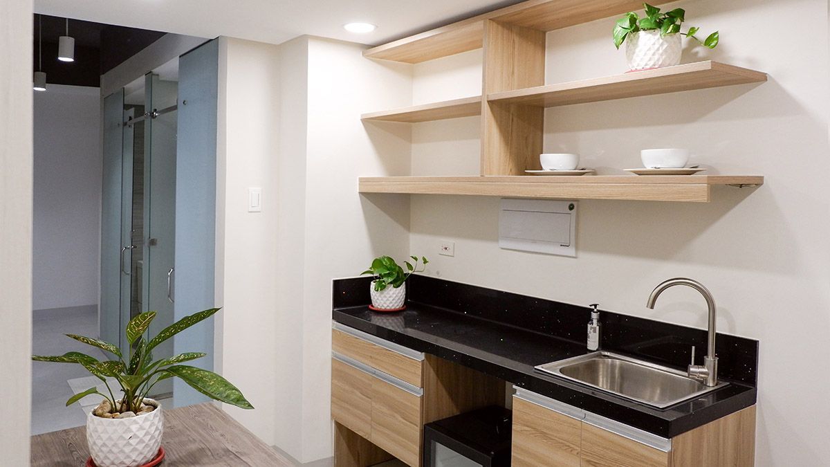 The Grid in Makati: A kitchen with a sink , cabinets , shelves and a potted plant.