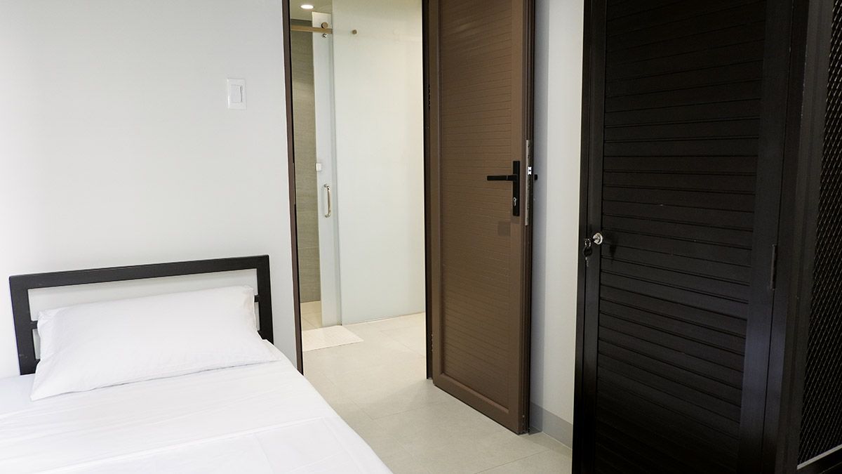 The Grid in Makati: A bedroom with a bed and a door leading to a bathroom.