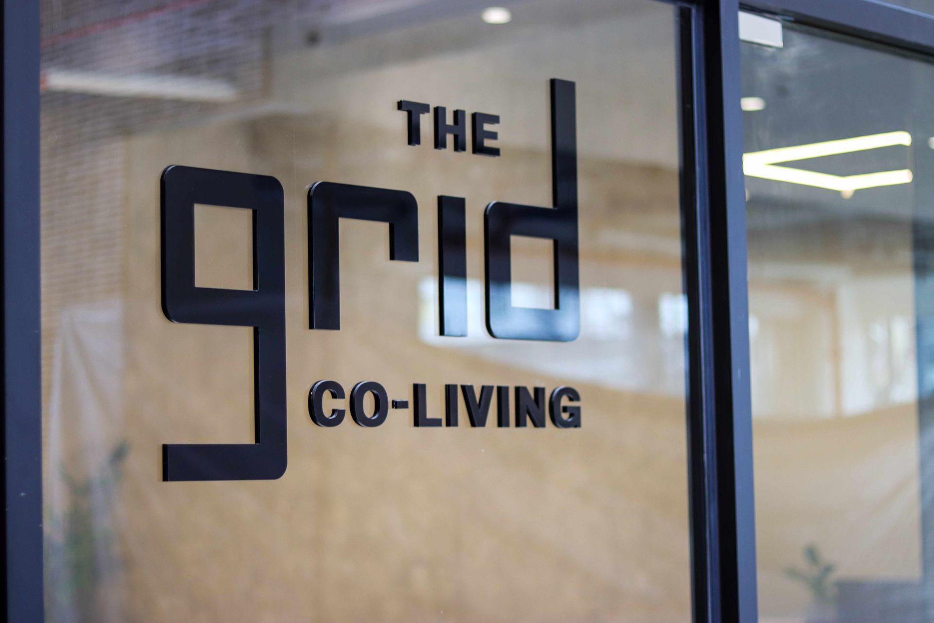 The Grid Co-Living entrance sign on glass door near Makati CBD