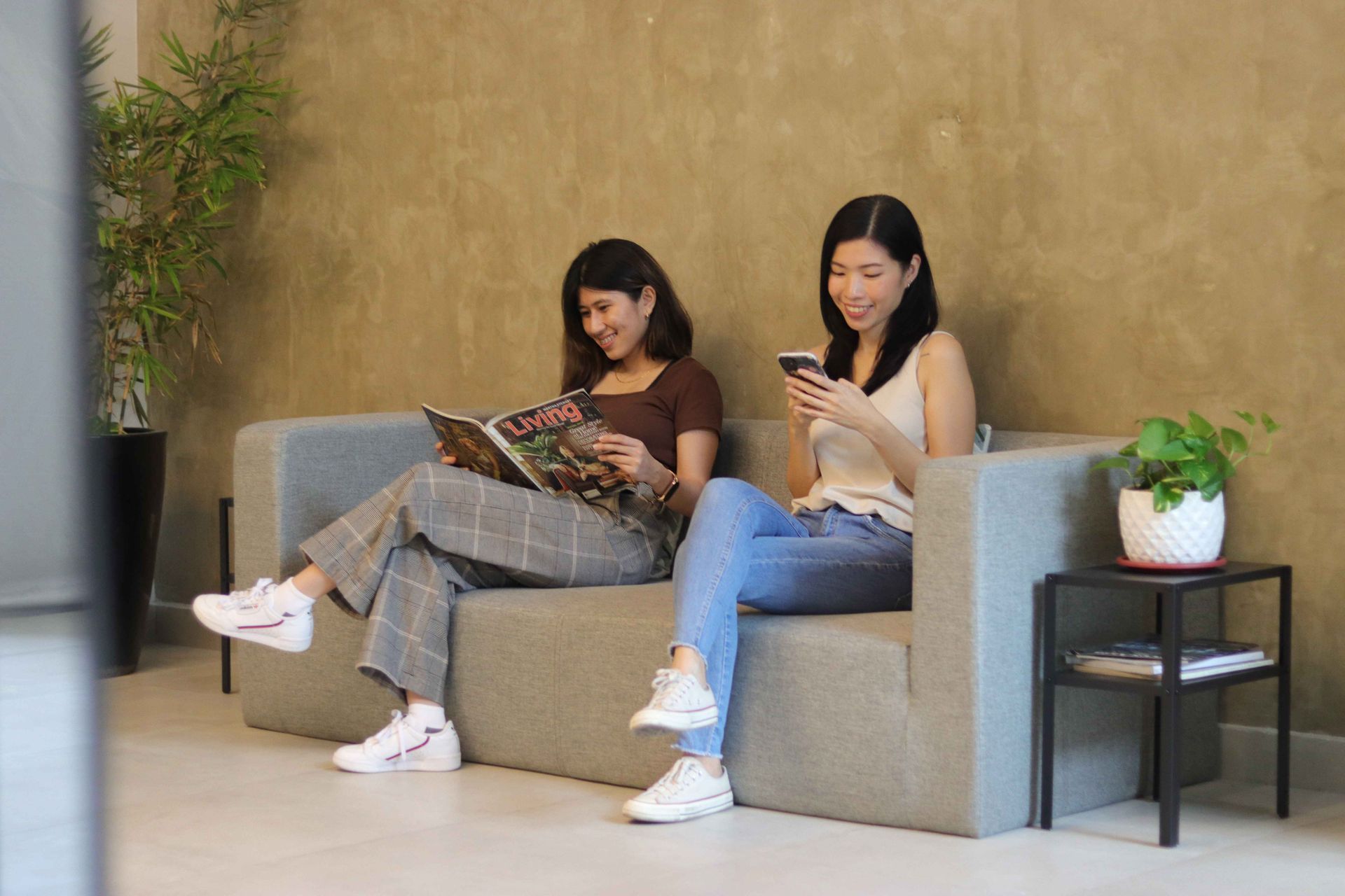 Two women relaxing on sofa at The Grid Co-Living lounge near Makati CBD