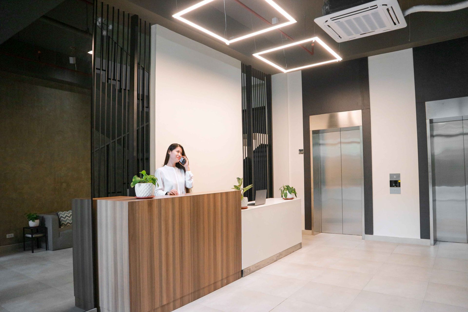Modern hotel lobby with receptionist at wooden front desk near Makati CBD